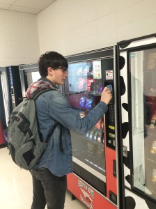 Sophomore Benjamin Boldt uses a credit card swiper at one of the vending machines. Since the card swipers have been installed, there as been an increase of sales at SHS.
